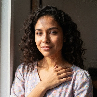 Woman holding her chest in discomfort, illustrating breast tenderness